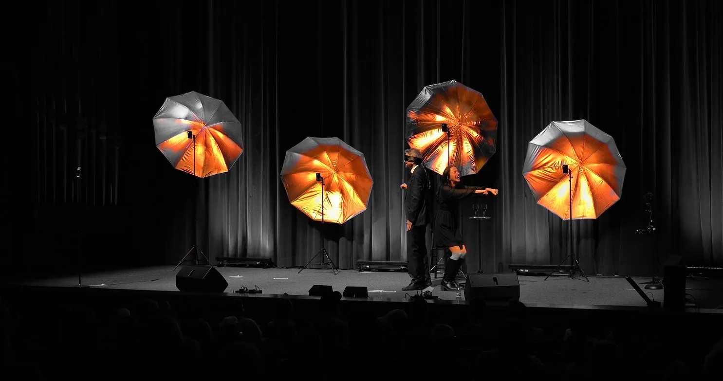 B&uuml;hnenshow mit verbundenen Augen und goldenen Schirmen